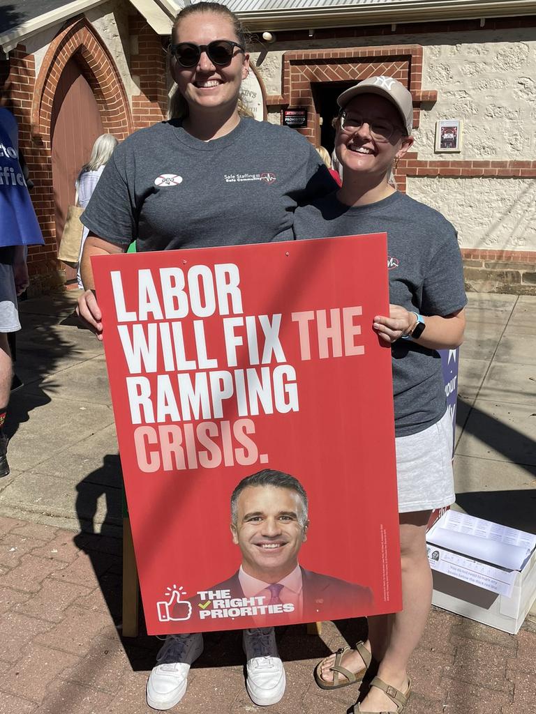 Paramedics Ashleigh “Ash the Ambo” Frier and Sian Wanstall with a Labor poster at the polling booth at the March 2022 election.