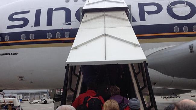 Damaged fuselage ... A scratch can clearly be seen on the letter 'n' as passengers reboard their flight to Singa...