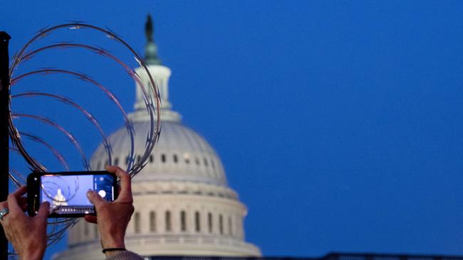 A woman takes a photo with her cell phone of the wire fencing that surrounds the US Capitol. Picture: Getty Images/AFP