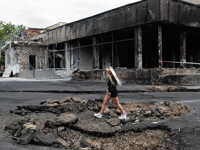 A young woman walks over a hole made by a rocket in Vinnytsia, Ukraine. Pictures: Getty Images