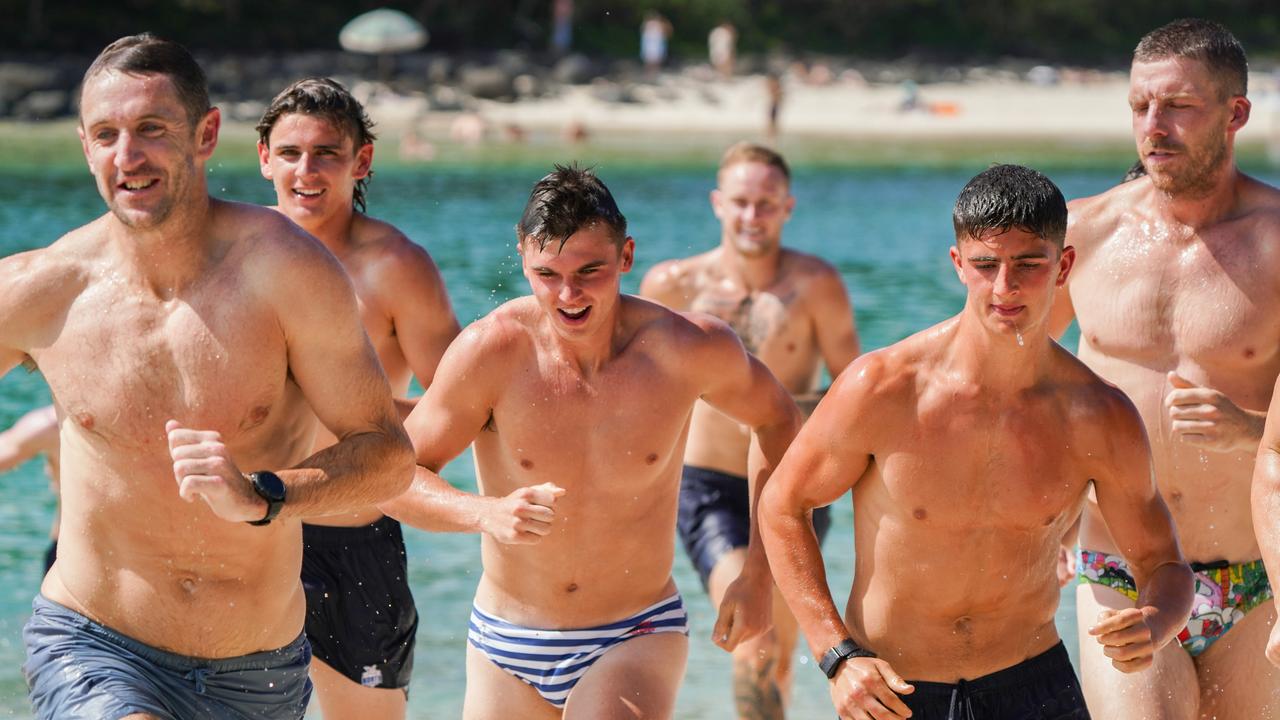 McKercher (centre) flanked by Harry Sheezel (right) and Roos head of development Michael Barlow (left) during a beach session at the club’s Gold Coast camp. Picture: North Melbourne FC