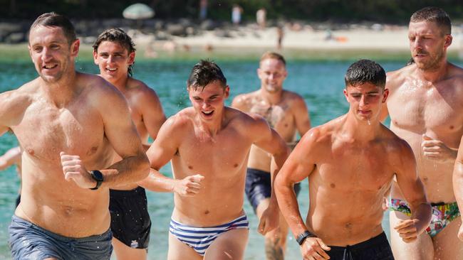 McKercher (centre) flanked by Harry Sheezel (right) and Roos head of development Michael Barlow (left) during a beach session at the club’s Gold Coast camp. Picture: North Melbourne FC