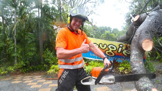 Harry Thomas removes a fallen tree downed by Cyclone Jasper outside Dougies Backpackers Resort in Port Douglas. Picture: Peter Carruthers