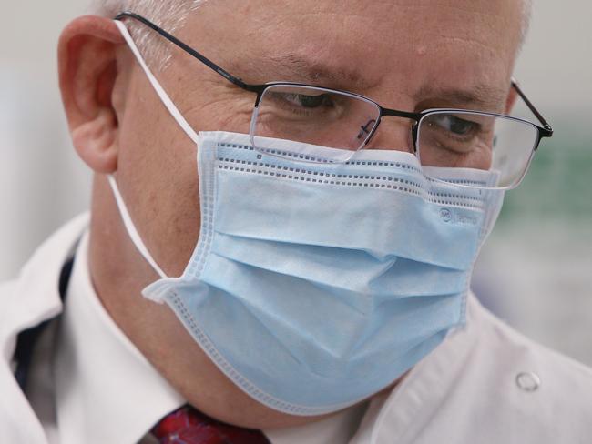 SYDNEY, AUSTRALIA - AUGUST 19: Prime Minister Scott Morrison is seen wearing a face mask as he visits with team members of  AstraZeneca on August 19, 2020 in Sydney, Australia. The Australian government has announced an agreement with the British pharmaceutical giant AstraZeneca to secure at least 25 million doses of a COVID-19 vaccine if it passes clinical trials.  The University of Oxford COVID-19 vaccine is currently in phase-three testing. If the vaccine proves to be successful, Australia will manufacture and supply vaccines and will be made available for free. The project could deliver the first vaccines by the end of this year or by early 2021. (Photo by Lisa Maree Williams - Pool/Getty Images)