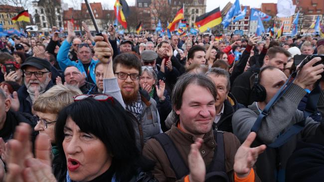 People at Erfurt cheer and wave German flags as they listen to AfD Thuringia leader Bjoern Hoecke speak at an election campaign rally of the far-right Alternative for Germany (AfD) on Saturday. Picture: Getty Images