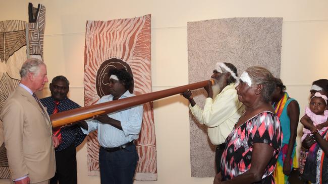 Yidaki master Djalu Gurruwiwi plays the Yidaki and gives Charles, Prince of Wales some healing magic. He is surrounded by his familynat the Buku-Larrnggay Mulka Centre. Picture: Keri Megelus