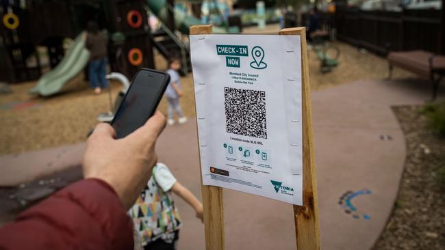 A parent uses the QR code check in at a playground in Victoria. Photo: Darrian Traynor/Getty Images.