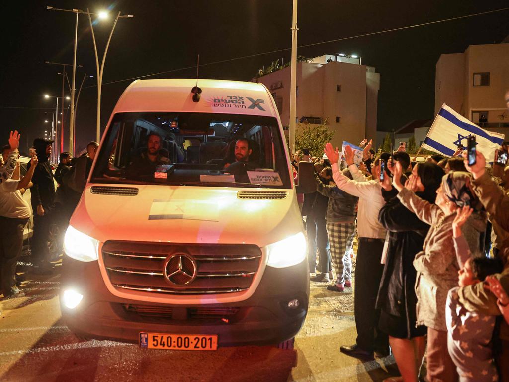 People cheer as a vehicle carrying hostages released by Hamas drives towards an army base in Ofakim, southern Israel, on November 26. Picture: AFP