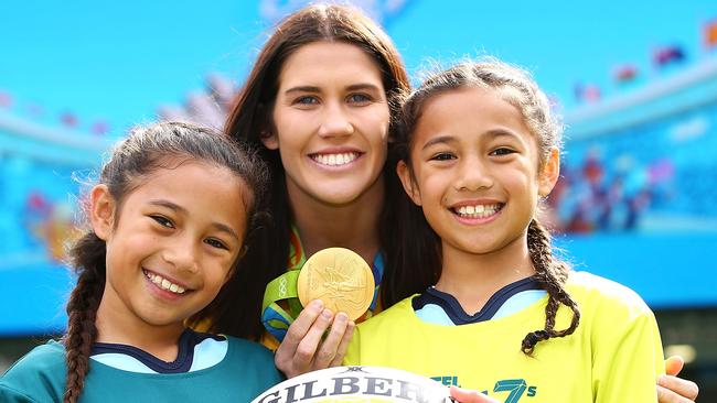 Australian women’s sevens player Charlotte Caslick with youngsters (left) Dyzire Lfotu-Moala left, 8, and her twin sister Gorjez.