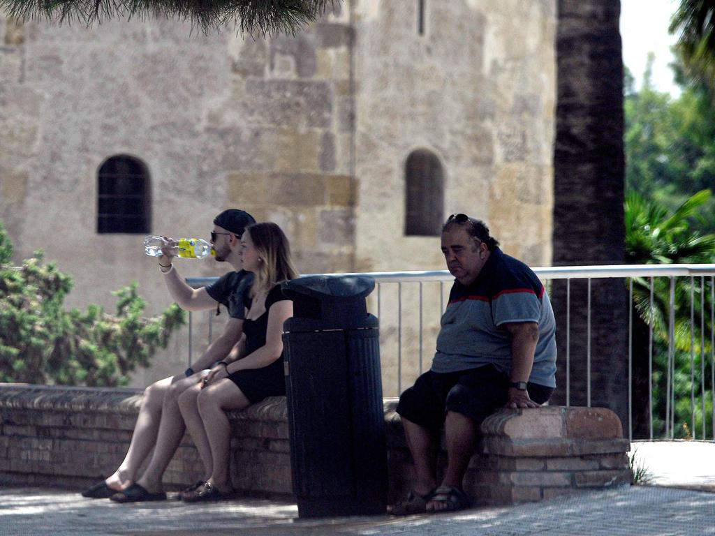 People rest in the shade in Sevilla, in the southern Spanish region of Andalusia. Picture: AFP