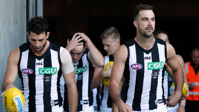 Steele Sidebottom (right) leads Collingwood out.