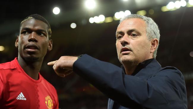 Manchester United's Portuguese manager Jose Mourinho (R) gestures to Manchester United's French midfielder Paul Pogba as he arrives on the pitch ahead of the UEFA Europa League group A football match between Manchester United and Zorya Luhansk at Old Trafford stadium in Manchester, north-west England, on September 29, 2016. / AFP PHOTO / PAUL ELLIS