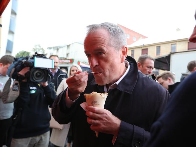 Opposition Leader Bill Shorten eating Indian, a butter curry on a walking through Salamanca markets in Hobart, Tasmania. Picture Kym Smith