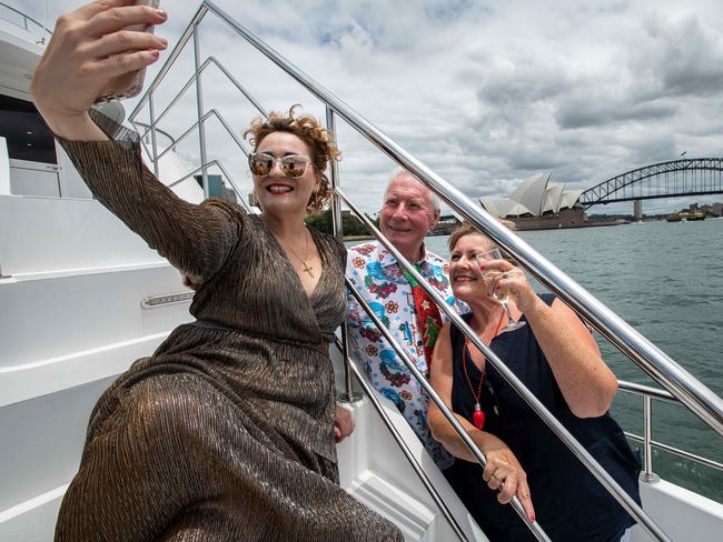 (L-R) Event host Honida Beram takes a selfie with Patrea  and Ed Stuttard onboard the Spirit of Migloo during a Sydney Harbour cruise, in Sydney, Sunday, December 13, 2020. Gold Coast couple Ed and Patrea Stuttard have done 49 cruises in the last 4 years and are desperate to get back to the hobby/lifestyle they love. (The Australian/Bianca De Marchi)