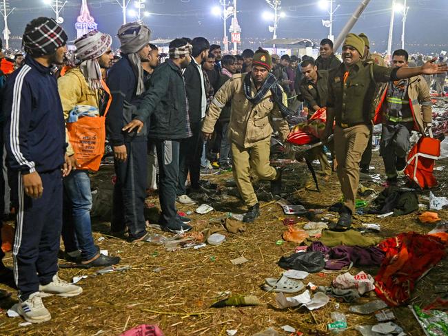 Police carry a victim of a stampede. Picture: AFP