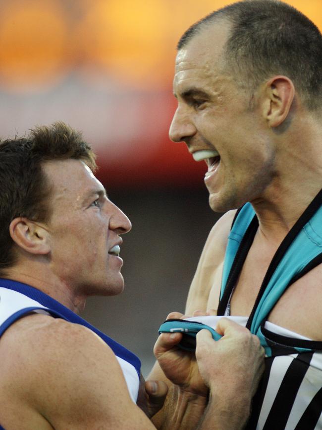 Warren Tredrea comes to grips with Kangaroo Brent Harvey in the preliminary final.