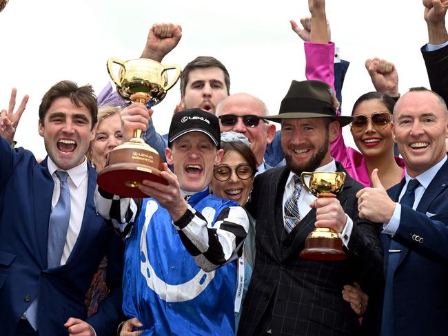 Jockey Mark Zahra (C) celebrates winning the Aus$8 million (6 million USD) Melbourne Cup horse race on Gold Trip with trainers David Eustace (centre L) and Ciaron Maher (centre R) in Melbourne on November 1, 2022. (Photo by William WEST / AFP) / -- IMAGE RESTRICTED TO EDITORIAL USE - STRICTLY NO COMMERCIAL USE --