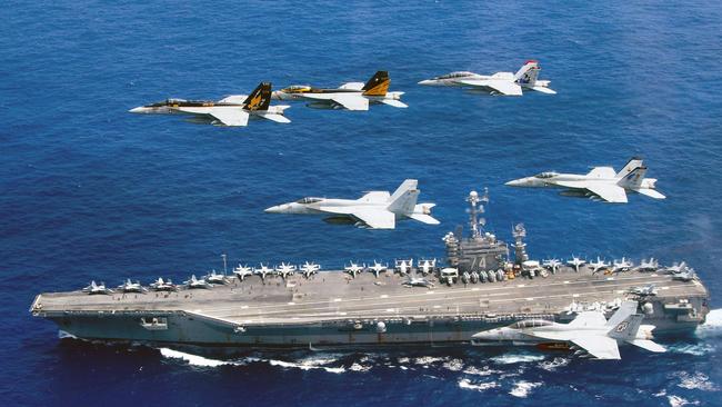 A formation of F/A-18E and F Super Hornets above the Nimitz-class aircraft carrier USS John C. Stennis in the Philippine Sea. Picture: AFP