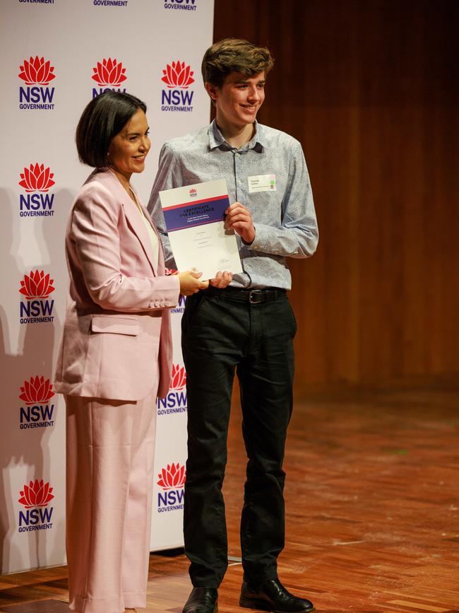 Prue Car, NSW Minister for Education and Deputy Premier, hands Thomas Collins of Sydney Grammar School one of his two first in course titles. Picture: Justin Lloyd