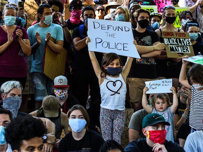 Children hold placards during a protest outside the residence of governor of Minnesota Tim Walz. Picture: AFP