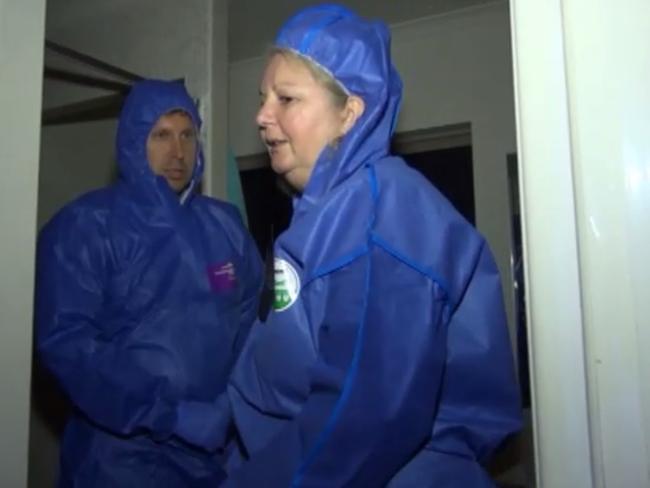 Torso killer Lindy Williams, clad in a forensic suit, shows police the scene of the crime after her arrest.