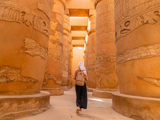 Female tourist walks between Pillars of the Great Hypostyle Hall from Karnak TempleEscape 6 October 2024Eds LetterPhoto - iStock