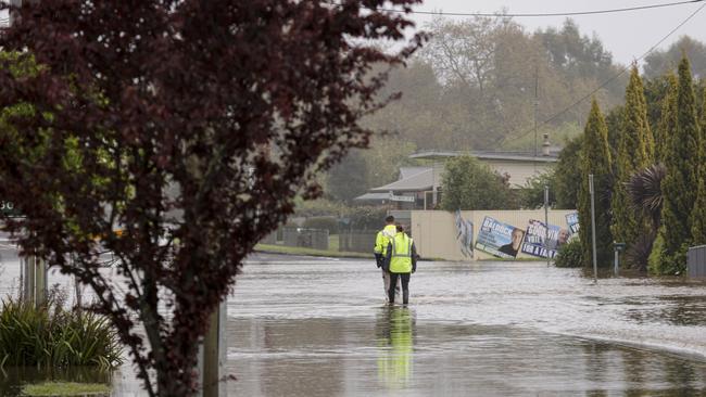 People walk through flood waters in the Main Street of Latrobe. Picture: Grant Viney