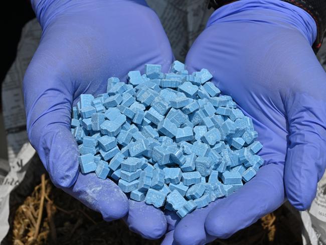 An Indonesian police officer shows synthetic drug methylenedioxy-methamphetamine (MDMA) also known as ecstacy during a press conference in Jakarta on November 5, 2019. - Indonesia's West Jakarta Metro police destroyed drugs seized during raids over the past three month raids. (Photo by ADEK BERRY / AFP)