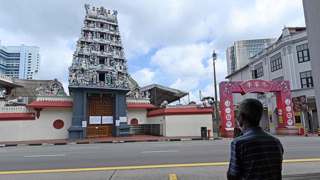 A man prays opposite a Hindu temple in the Chinatown district of Singapore yesterday. Picture: AFP