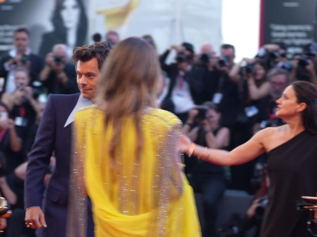 An usher appears to direct Styles to stand next to Wilde. Picture: Getty Images