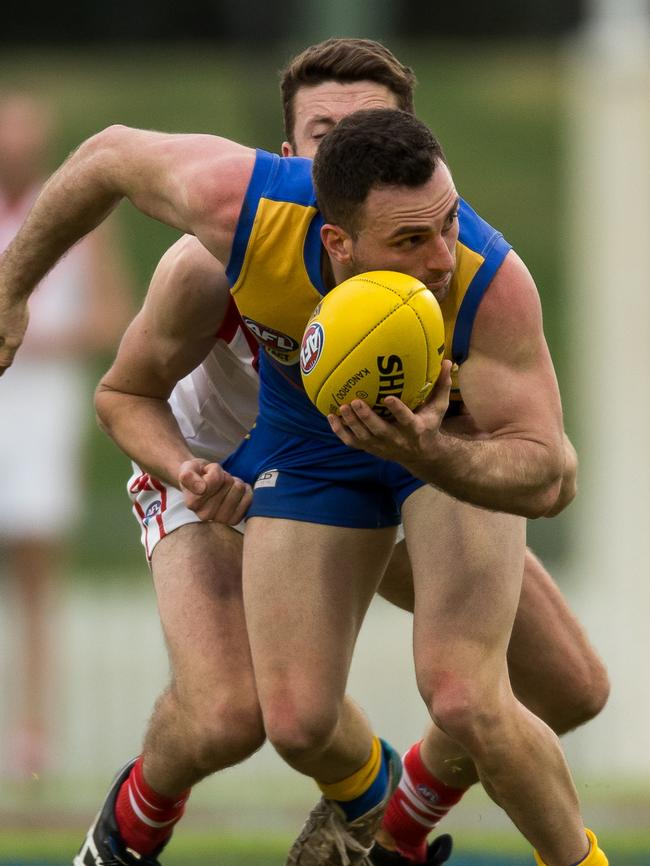 Dean Costello of the Eagles just about to handball off.