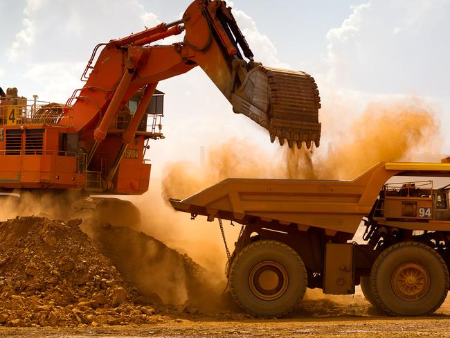 A haul truck is loaded by a digger with material from the pit at Rio Tinto Group's West Angelas iron ore mine in Pilbara, Australia, on Sunday, Feb. 19, 2012. Rio Tinto Group, the world's second-biggest iron ore exporter, will spend $518 million on the first driverless long-distance trains to haul the commodity from its Western Australia mines to ports, boosting efficiency. Photographer: Ian Waldie/Bloomberg