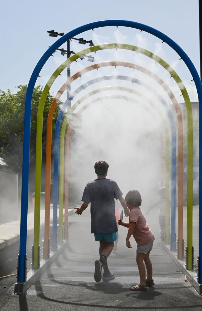 Children walk through a mist tunnel to cool at the Australian Open tennis. Picture: Saeed Khan/AFP