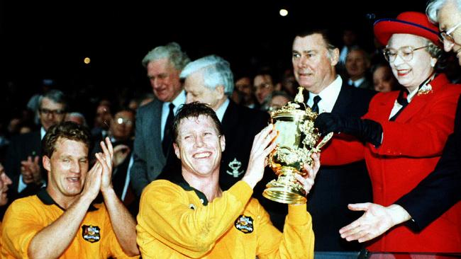 Captain Nick Farr-Jones smiles as he is presented the Rugby World Cup trophy by Queen Elizabeth II after Australia defeated England in the final at Twickenham in 1991.