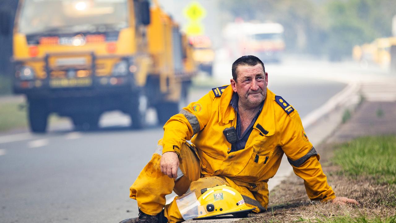 Rural firefighters stop to catch their breath as a wild bushfire roared towards Peregian Beach for the second time in a month. Photo Lachie Millard