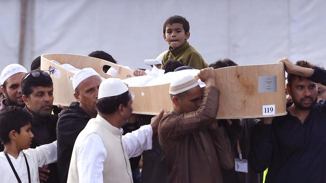 A child looks on as mourners carry the coffin of a victim of the mosque shootings. Picture: AFP 