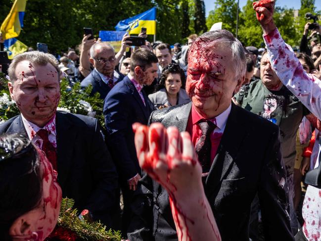 Ambassador Sergey Andreev reacts after being covered with red paint. Picture: AFP