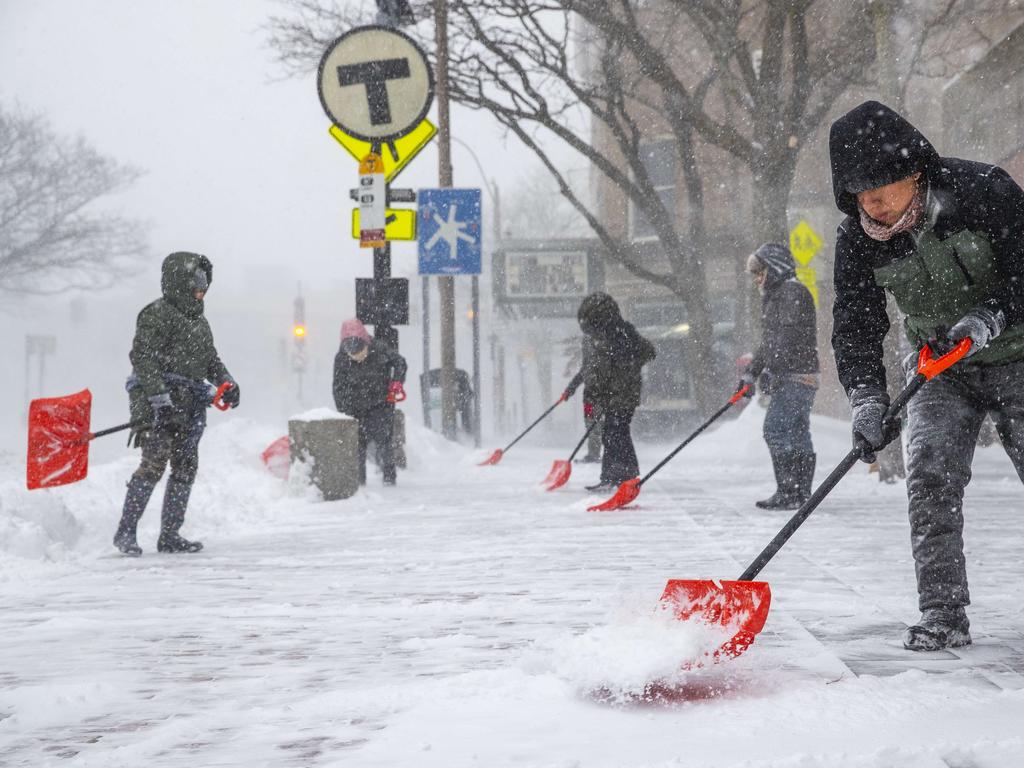 People shovel outside the Davis Square MBTA station during the snowstorm in Someville, Massachusetts. Picture: Getty