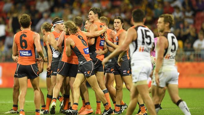 The Giants celebrate a goal as Luke Hodge and Sam Mitchell look for answers.