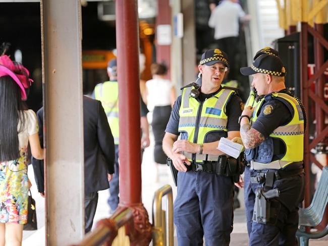 Police watch over racegoers returning to the city at Flinders Street Station after Melbourne Cup Day 2014 at Flemington Racecourse. Picture: Nathan Dyer