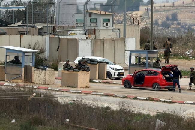 Palestinians sometimes wait hours on their way home from work while cars are searched and IDs verified