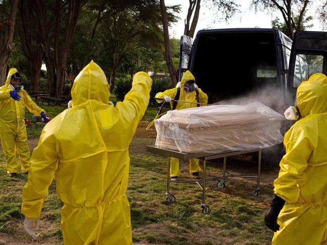 (FILES) In this file photo taken on April 15, 2020 Workers at the Campo Santo cemetery in the northern city of Piura, Peru, disinfect the coffin of a Covid-19 victim. - More than one million people have died from the coronavirus, according to an AFP toll, with no let-up in a pandemic that has ravaged the world economy, inflamed diplomatic tensions and upended lives from Indian slums and Brazilian jungles to America's biggest city. (Photo by Sebastian ENRIQUEZ / AFP)