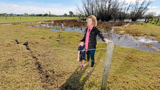 FRUSTRATING: Beck Plunkett-Hicks and son Cooper look over the damage to fence and property an out-of-control car caused at the unsealed section of Prince St. Picture: Adam Hourigan Photography