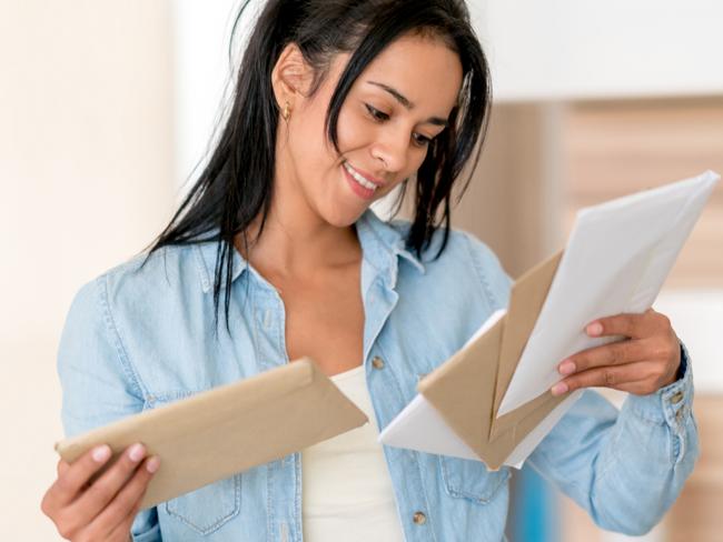 Portrait of a casual woman at home checking her mail and looking happy - lifestyle concepts