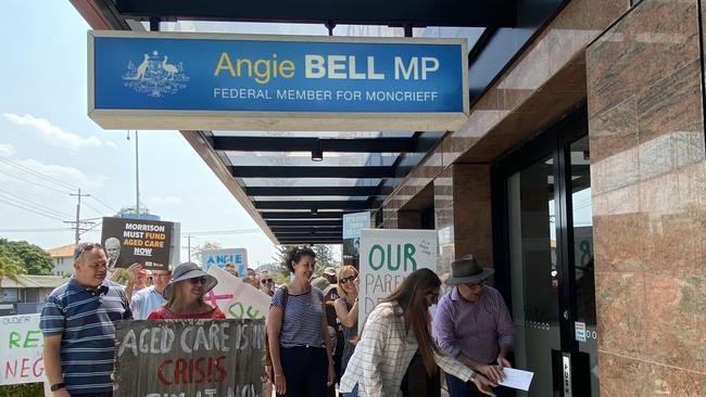 Member for Gaven Meaghan Scanlon and Queensland Senator Murray Watt slide their aged care petition under the door of Moncrieff LNP MP Angie Bell in November.