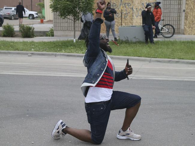 A protester drops to the pavement to yell at Minnesota state troopers providing security after another night of protests over the death of George Floyd. Picture: AP