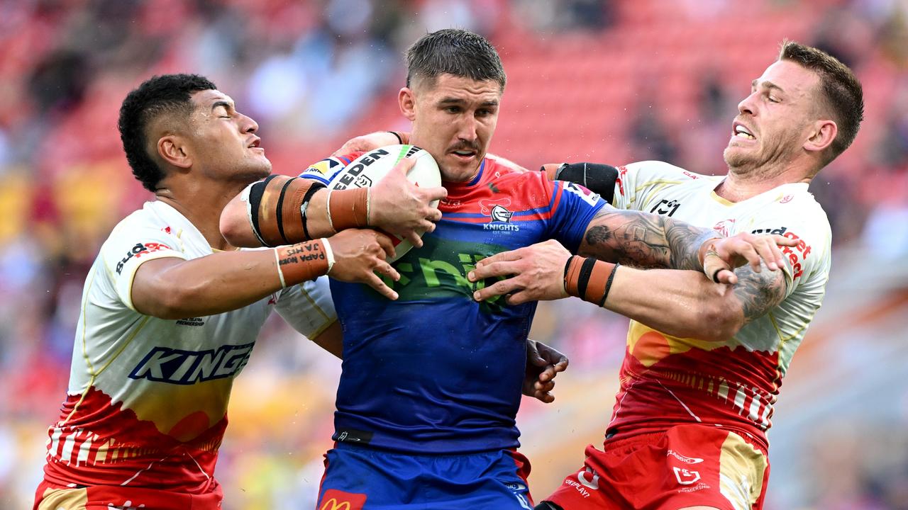 BRISBANE, AUSTRALIA - APRIL 28: Dylan Lucas of the Knights takes on the defence during the round eight NRL match between Dolphins and Newcastle Knights at Suncorp Stadium, on April 28, 2024, in Brisbane, Australia. (Photo by Bradley Kanaris/Getty Images)