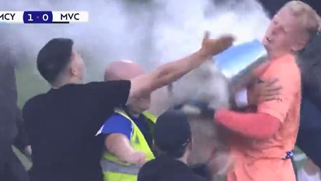 Tom Glover reacts after being struck by a bucket thrown by a fan.