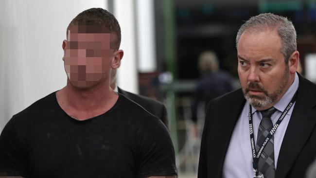 Tasmania Police escort a 29-year-old Tasmanian man off a Virgin Australia flight from Melbourne on June 13, 2018, after he was extradited from Queensland.