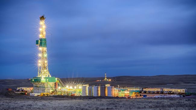 An oil fracking drill rig at night.